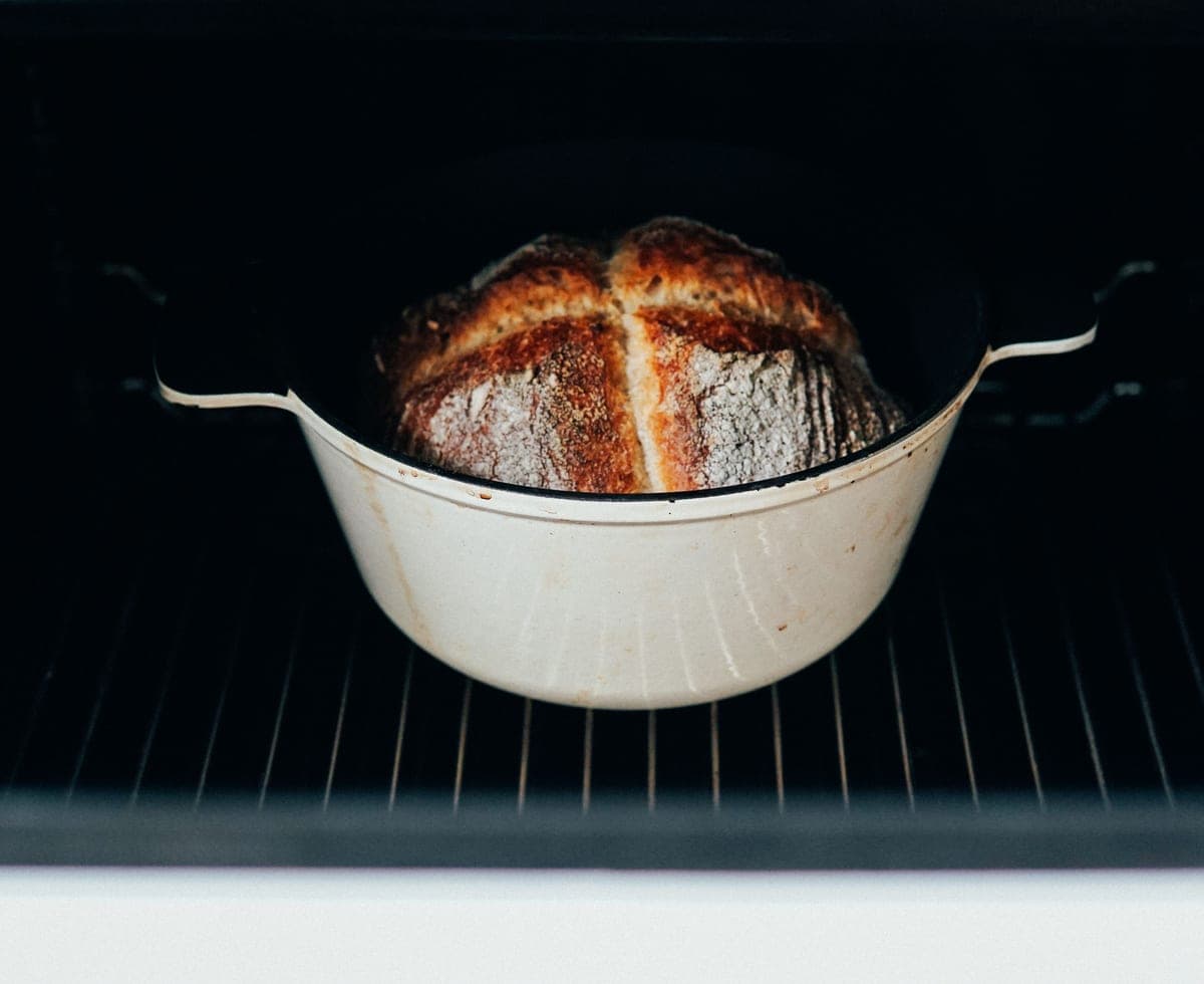 A brightly enameled cast iron dutch oven on a kitchen counter